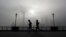 FILE - People jog past the Pudong Financial District shrouded in fog and pollution at the Shanghai Bund in Shanghai, China, Thursday, April 14, 2016. Air pollution has caused 5.5 million premature deaths globally in 2013, outpacing disease, a new study has found.
