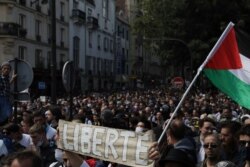 Protestors hold up a banner which reads 'freedom' in French during a demonstration in Paris, France, July 31, 2021. Demonstrators gathered in several cities in France on Saturday to protest the COVID-19 pass.