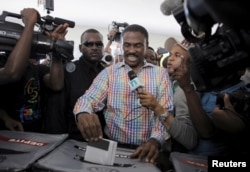 Presidential candidate Jude Célestin (C) drops his ballot in an electoral bin at a polling station in Port-au-Prince, Haiti, Oct. 25, 2015.