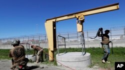 在墨西哥城市蒂华纳和美国加州城市圣迭戈之间所挖的地道的入口处，边界巡逻员在工作（2017年3月6日）