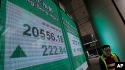 一名香港市民走过显示恒生指数的电子显示屏。 （2016年1月8日）