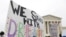 FILE - Demonstrators rally outside the Supreme Court as justices were scheduled to hear arguments in the consolidation of three cases regarding the Trump administration’s bid to end DACA, in Washington, Nov. 12, 2019.