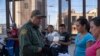 In this file photo taken on May 16, 2019 U.S. Customs and Border Protection agent checks documents of a small group of migrants, who crossed the Rio Grande from Juarez, Mexico, in El Paso, Texas.