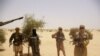 Fighters from Islamist group Ansar Dine stand guard during a hostage handover, in the desert outside Timbuktu, Mali, April 24, 2012.