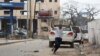 A man raises his hands as he runs from the scene of a suicide bomb attack outside the Hotel Naso-Hablod in Somalia's capital, Mogadishu, June 25, 2016.