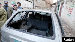 8일 예멘 사나에 폭탄 테러가 발생한 가운데, 사람들이 파손된 차량 주변에 몰려있다.