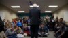 People look on as Democratic presidential candidate Sen. Bernie Sanders of Vermont speaks during a meeting with volunteers at a canvass lunch at Wartburg College in Waverly, Iowa, Jan. 30, 2016. 