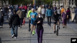 图为人们正在穿越西班牙马德里的托莱多大桥，周六，西班牙人能够外出锻炼，这是自封锁开始抗争以来的七周来的第一次。（2020年5月3日）