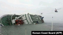 照片显示直升机前往搭救在前往济州岛途中出事的渡轮上的乘客。（2014年4月16日）