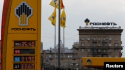 The logo of Russia's top crude producer Rosneft is seen on a price information board of a gasoline station in Moscow July 17, 2014.
