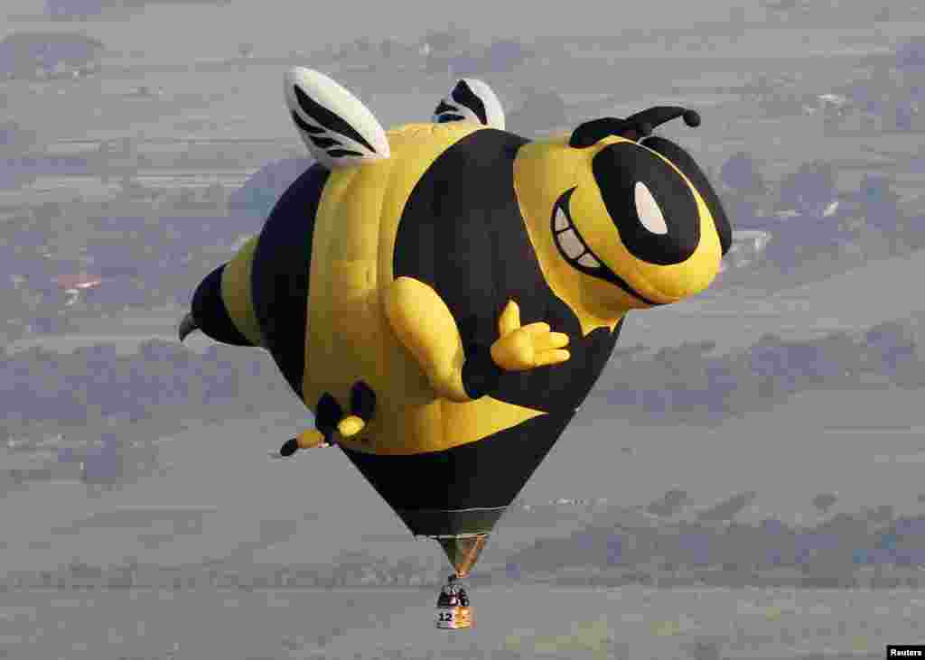 Balon udara berbentuk lebah terbang di atas kota Lubao, Pampanga, Filipina.
