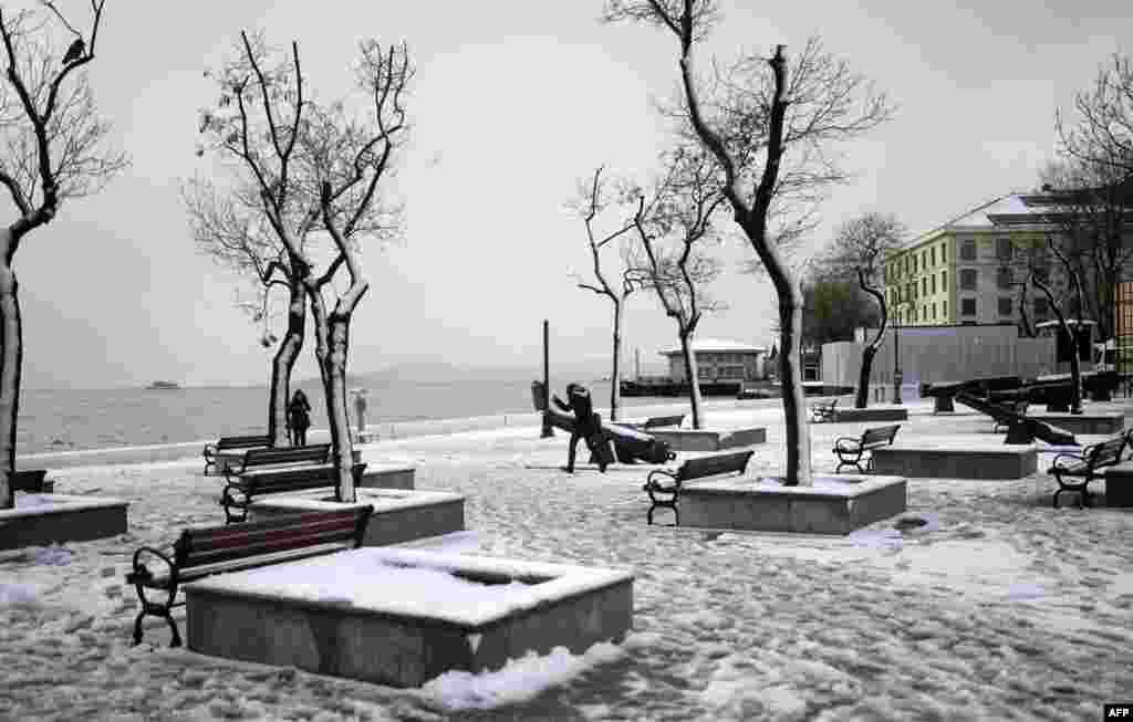 Warga setempat berjalan di Lapangan yang diselimuti salju di kota Istanbul,Turki. 
