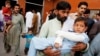 A man carries a child injured from an earthquake, in Peshawar, Pakistan, Oct. 26, 2015.