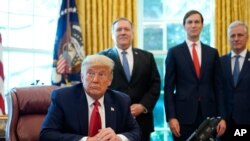 President Donald Trump listens while on a phone call with leaders of Sudan and Israel in the Oval Office of the White House, Friday, Oct. 23, 2020, in Washington. Secretary of State Mike Pompeo and Jared Kushner listen. (AP Photo/Alex Brandon)