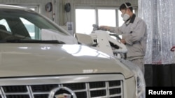 中国北京一家凯迪拉克4S店的工人正在修理汽车。（2016年3月14日）
