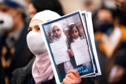 FILE - Demonstrators hold images of Yemeni civilians who were barred from immigrating to the United States during an "I Want My Miracle Back" rally, in the Bronx borough of New York, March 24, 2021.