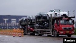 一辆大卡车运出特斯拉上海工厂出产的电动车。（2021年5月13日）