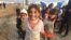 Little girls here in Khazir Camp, Kurdish Iraq say they like to pretend camp workers are giving them papers to get supplies like food and fuel on Dec. 1, 2016. (H.Murdock/VOA)