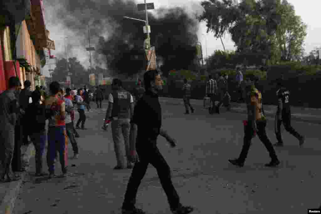 Civilians gather at the site of a car bomb attack in Amara, southeast of Baghdad, July 2, 2013. 