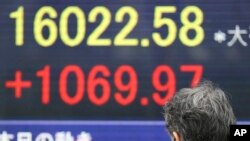 15일 일본 도쿄의 증시 현황판. 이 날 니케이 지수는 7% 이상 급등하며 1만6천 선을 넘겼다.
