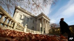 FILE — In this Nov. 19, 2010 file photo, a woman walks past the front entrance to Marble House, a Gilded Age mansion in Newport, Rhode Island.