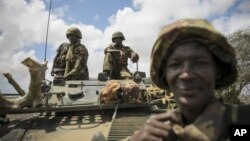  In this photo released by the African Union-UN Information Support Team, Kenyan soldiers with the African Union Mission in Somalia sit on top of an armored vehicle in Saa'moja, north-west of the port city of Kismayo, October 1, 2012. 