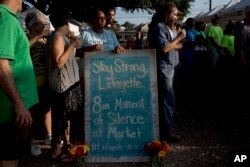 A crowd at a farmers market in Lafayette, La., pays respects July 25, 2015, for victims of a deadly shooting two days earlier at a movie theater in the city..