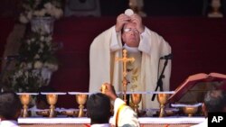 FILE - Pope Francis prepares for Holy Communion during mass at Colombo's seafront Galle Face Green, in Sri Lanka, Jan. 14, 2015.