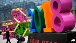 北京一家零售和批发商场大楼前写有2018“生意兴隆，财源广进“字样的商场装饰物。 （2018年7月9日）