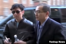 한국으로 망명한 사실이 확인된 태영호 영국주재 북한 공사(오른쪽)가 지난해 김정은 국방위원장의 친형 김정철이 영국 가수 에릭 클랩튼의 런던 공연장을 찾았을 때 에스코트하던 모습. 일본 TBS 방송화면 캡처.