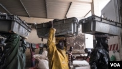 资料照片：人们在塞内加尔的乔尔海岸拖运一天的渔获，主要是较小的沙丁鱼。西非水域的过度捕捞已经耗尽了优质鱼类的资源。(2017年5月29日)