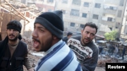 30일 시리아 다마스쿠스 인근 번화가에 정부군의 미사일 공격이 있은 후 사람들이 시체를 옮기고 있다. 