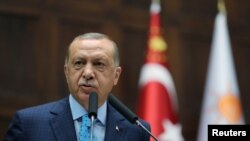 Le président turc Tayyip Erdogan devant les parlementaires de son parti au pouvoir lors d'une réunion au parlement à Ankara, en Turquie, le 24 juillet 2018.