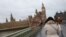 A woman holds her umbrella during a gust of wind on Westminster Bridge after Storm Darragh hit the country, in London on Dec. 7, 2024.