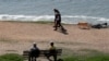 FILE - Elderly people walk on Avon Beach as the spread of the coronavirus disease (COVID-19) continues, Christchurch, Britain, April 21, 2020.