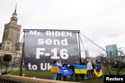 资料照片：支持乌克兰的抗议者在美国总统拜登访问波兰期间下榻的酒店外呼吁拜登批准向乌克兰提供美制F-16战斗机。(2023年2月22日)