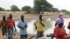 Villagers gather in front of a dam near the village of Labgar in northern Senegal on 12 Nov 2009. There is little to show for it apart from small acacia shrubs, but Senegal's leader believes in a Great Green Wall that will stem desertification across Afri