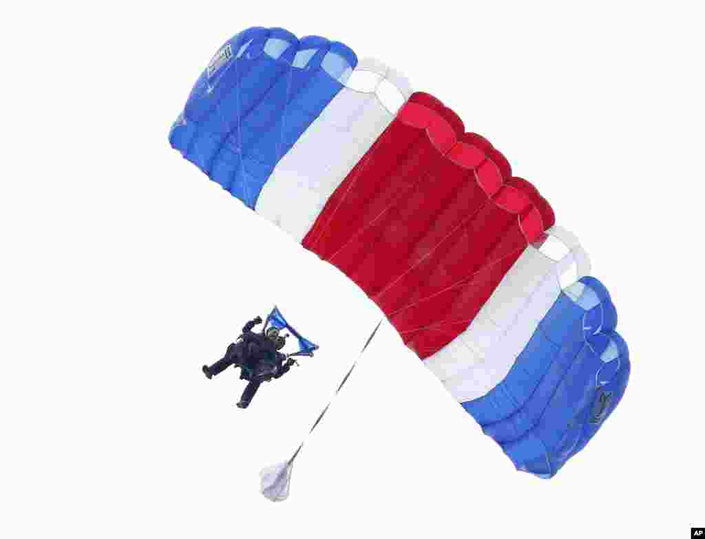 Former president George H.W. Bush, strapped to Sgt. 1st Class Mike Elliott, a retired member of the Army&#39;s Golden Knights parachute team, float to the ground during a tandem parachute jump near Bush&#39;s summer home in Kennebunkport, Maine, June 12, 2014.