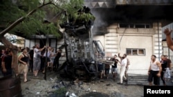 팔레스타인 주민들이 19일 폭탄 공격을 받아 파손된 차량을 살펴보고 있다.