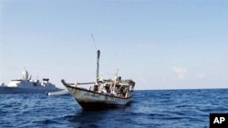 A handout picture received from The Netherlands Ministry of Defence shows a boat containing alleged Somali pirates being apprehended by Netherlands warship Evertsen acting as part of EU counter piracy operations at sea some 150 nautical miles off the coas