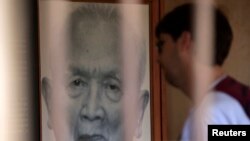 A tourist looks at a portrait of former Khmer Rouge leader "Brother Number two" Nuon Chea at the Tuol Sleng Genocide Museum in Phnom Penh August 2, 2014. 