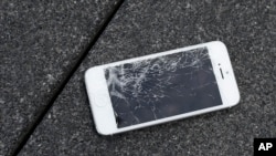 FILE - An Apple iPhone with a cracked screen after a drop test is seen at the offices of SquareTrade in San Francisco.