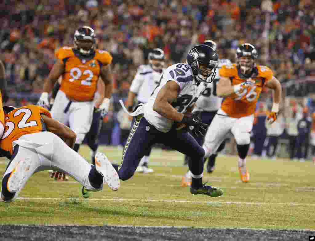 Seattle Seahawks' Doug Baldwin (89) runs from Denver Broncos' Wesley Woodyard (52) during a 10-yard touchdown reception in the second half of the NFL Super Bowl XLVIII football game Sunday, Feb. 2, 2014.