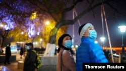 Duan Ling and her husband Fang Yushun walk on a street, almost a year after the global outbreak of the coronavirus disease (COVID-19) in Wuhan
