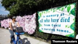 زنی در مقابل یادبود جان‌باختگان کووید۱۹ در قبرستانی در نیویورک