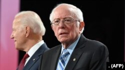 美国争取民主党总统候选人的参议员桑德斯（右）和前副总统拜登在2019年12月的一次辩论上。