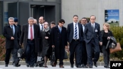 Negosiator utama kelompok Suriah Hadi al-Bahra (kedua dari kanan) dan Sekretaris Jenderal Dewan Nasional Suriah Badr Jamous (empat dari kanan) diba dengan delegasi oposisi pada pembicaraan perdamaian Suriah di Jenewa (25/1). (AFP/Philippe Desmazes)