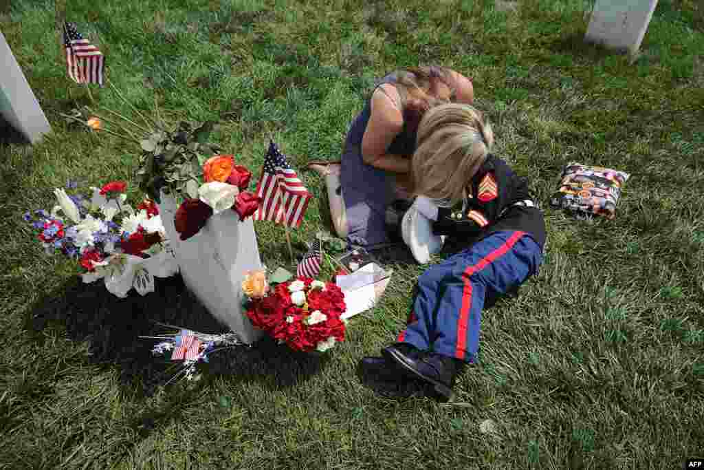 Brittany Jacobs of Hertford, North Carolina, embraces her son, Christian Jacobs, 6, next to the grave of her husband, U.S. Marine Corps Sgt. Chris Jacobs, in Section 60 at Arlington National Cemetery on Memorial Day in Arlington, Virginia.