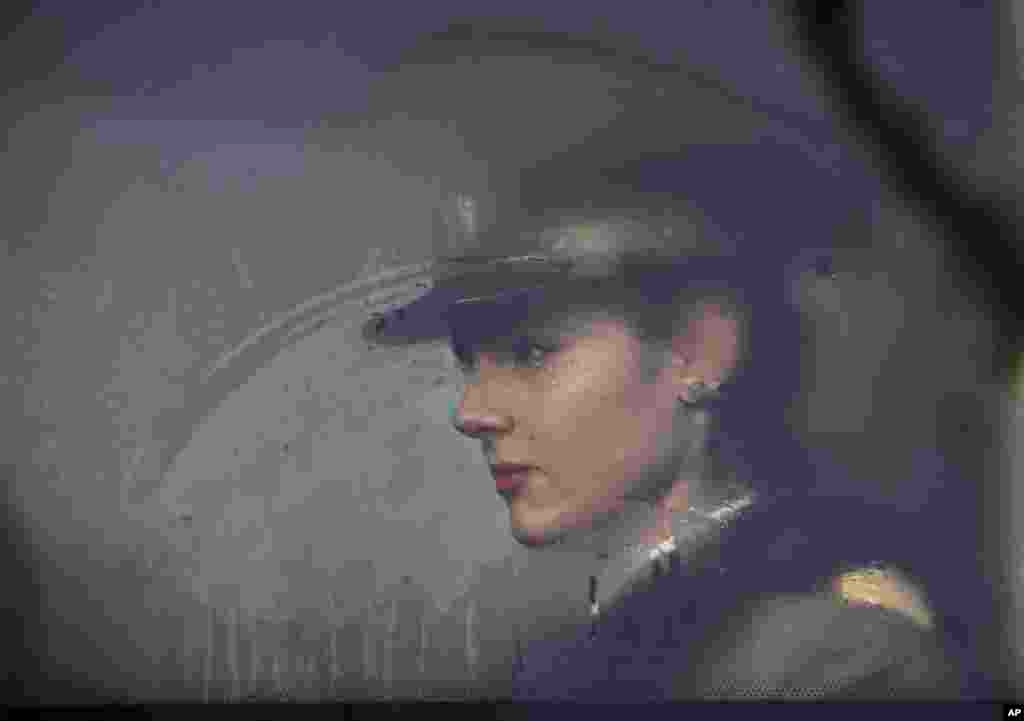 និស្សិត​ពេទ្យ​យោធា​រ៉ូមានី​អង្គុយ​នៅ​លើ​រថយន្ត​បឺស​មួយ​មុនពេល​ចូលរួម​ក្នុង​ក្បួន​ដង្ហែ​ថ្ងៃ​បុណ្យ​ជាតិ​ក្នុង​រដ្ឋធានី​ប៊ុយការ៉េស។