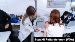 Mwananmke mmmoja akipokea chanjo ya covid huko East Hollywood Farmer’s Market, Los Angeles, CA.